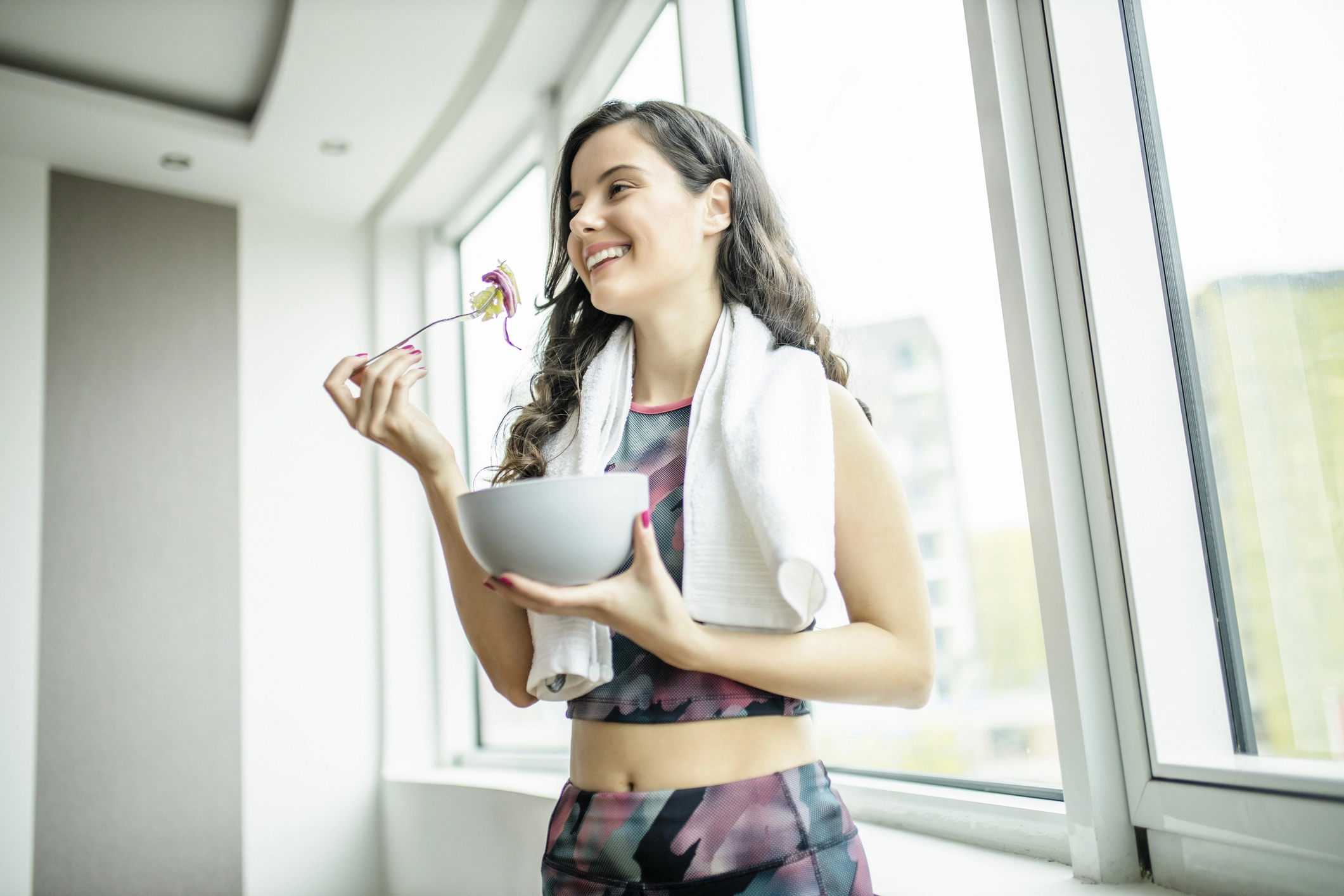 Chica joven disfrutando de la comida tras hacer ejercicio físico